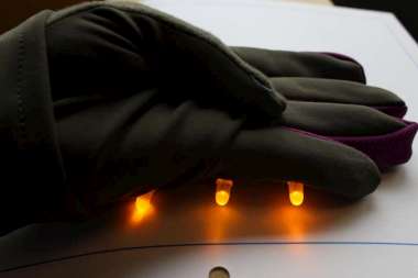 green glove with 3 glowing yellow LEDs